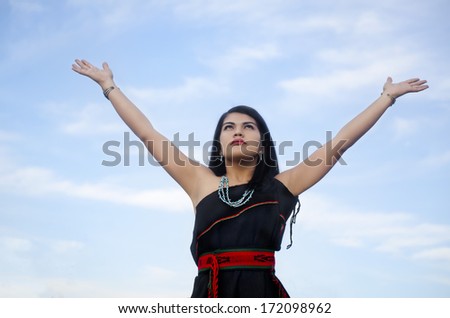 Woman standing outside with arms outstretched
