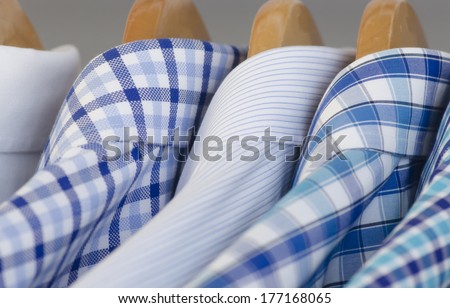 Closeup photo of Mens\'s dress shirts hanging.