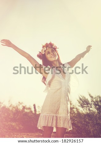 Carefree elated cheering woman in spring or summer desert landscape full of hope and vitality.  Multiracial girl raising her arms up smiling happy. Mixed race Latina Caucasian female model.
