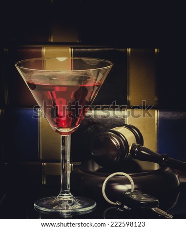 Drink driving law legal concept image - car keys - wine glass and gavel with legal books in background,