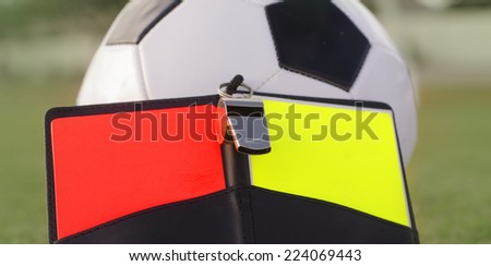 Football referee red and yellow card, whistle and ball.  Rules of the game concept image