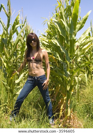 Attractive Model in cornfield wearing jeans bikini top and eyewear.