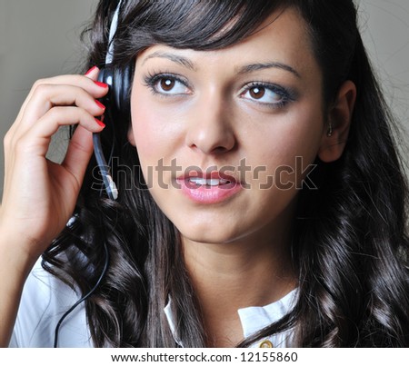 Young business woman using head phone to answer call