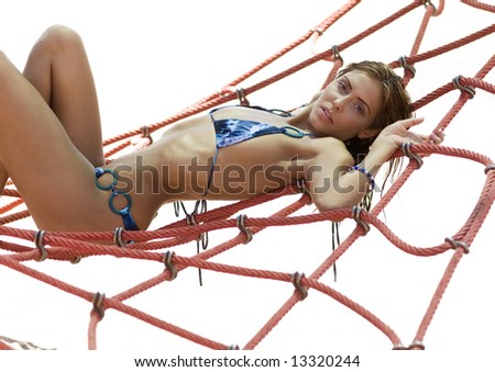Beautiful young woman wearing bikini laying on rope