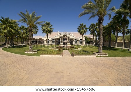 Luxurious Home with large front yard and  driveway with tropical trees and foliage.