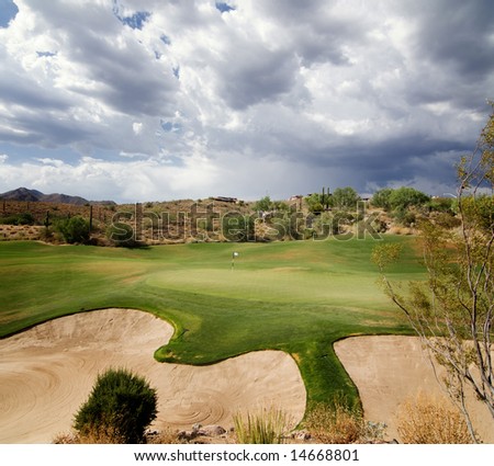 Dramatic sky with sunlight shining on beautiful desert golf course green in Scottsdale,AZ