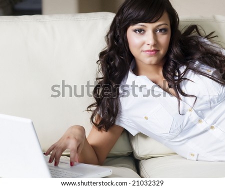 Young woman using laptop computer to shop and make purchases in the comfort of her home.