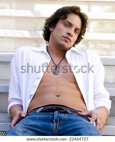 Portrait of a handsome man with unbuttoned shirt showing ripped abs