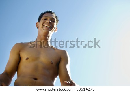 Laughing happy shirtless man outside on hot sunny day