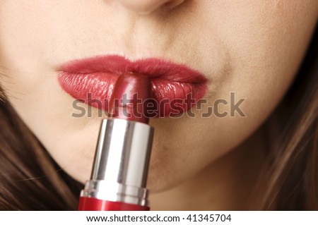 Close up of a female applying red lipstick, white background. Close up of a female applying red lipstick, white background.