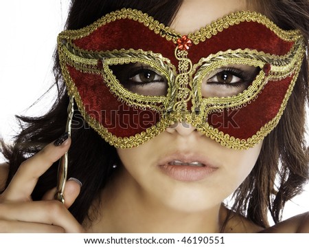Beautiful mysterious woman\'s face behind ornate red and gold mask
