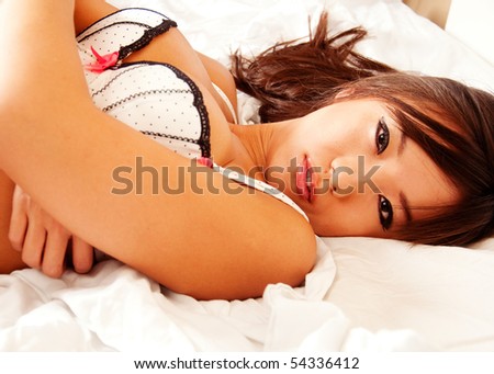 stock photo Beautiful sexy curvy Asian woman in lingerie lying down in bed 