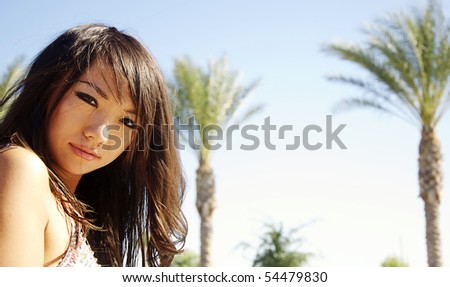 Beautiful Asian woman in bikini in tropical location