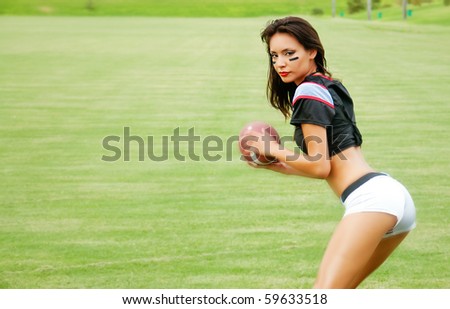 Beautiful young woman wearing American football outfit throwing football