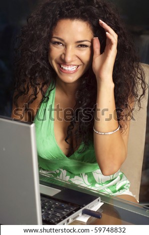 Happy smiling woman sitting at table with laptop computer