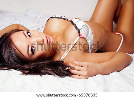 stock photo Beautiful Asian woman wearing lingerie lying in bed