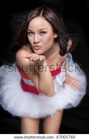 Beautiful young woman blowing kiss dressed in red Christmas santa outfit and mini skirt tutto.