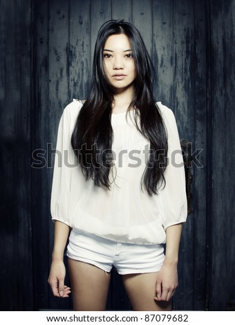 Beautiful young Asian model with long dark straight hair wearing white sheer top