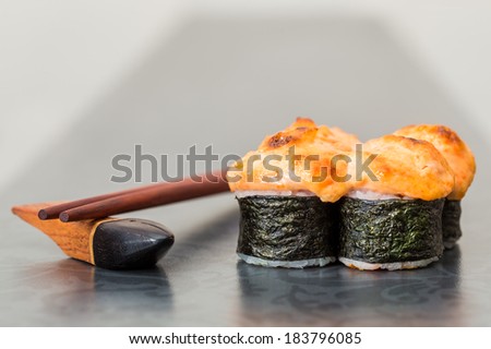 Baked sushi roll on grey background