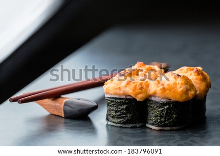 Baked sushi roll on dark background