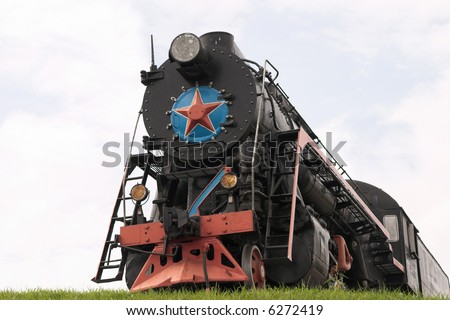Old restored steam locomotive on a pedestal