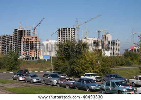 Column of wedding automobiles on a background of builded houses
