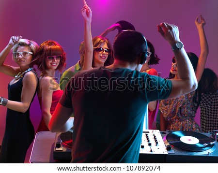 sexy, young women dancing and flirting with the dj in a night club