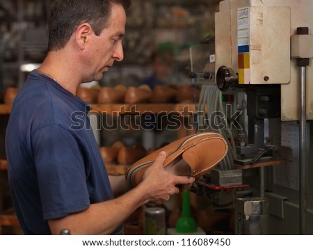 adult man working in a shoe factory, checking the quality of the products