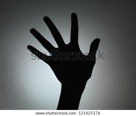 hand silhouette with fingers spread backlit on grey gradient background