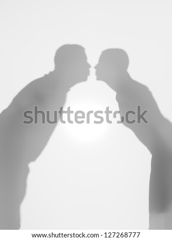 couple silhouettes kissing, behind a diffuse surface