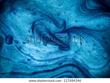 macro of blue pigment mixed with oil, waves