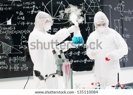 close-up of two people analyising substances in a chemistry lab with a blackboard with chemical formulas on the background