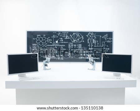general- view of a chemistry laboratory with a lab table, two microscopes and a blackboard on the background