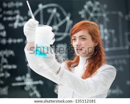 general-view  of a student analyzing blue liquids and gas in a chemistry lab with a blackboard on the background
