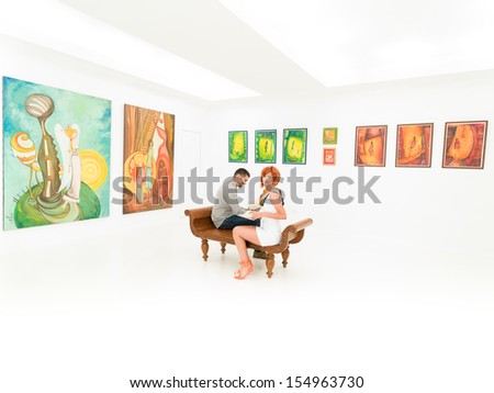 young couple sitting on a bench in art gallery, with colorful paintings displayed on white walls