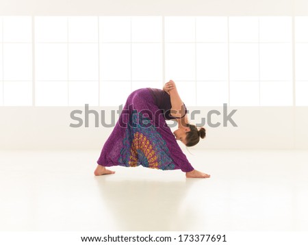 young,  woman practicing yoga posture, with face obscured, indor shot