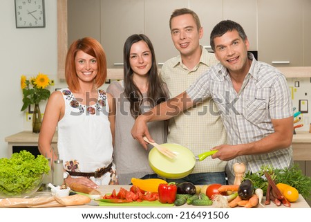 front view of young caucasian people standing in kitchen, cooking