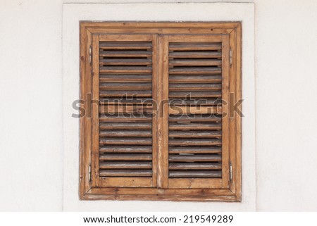 rustic window closed with wooden exterior shutters