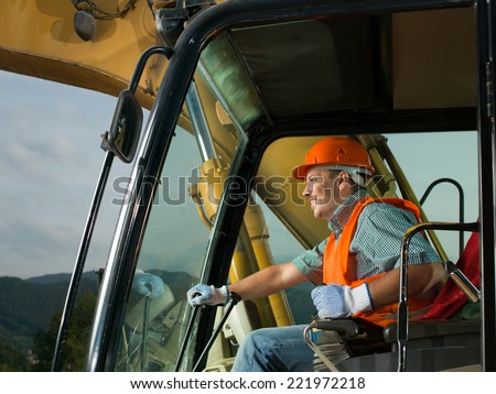 male operator driving excavator on construction building site