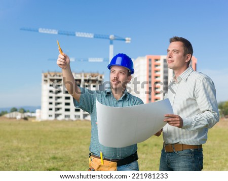 architect and construction manager discussing plans on site