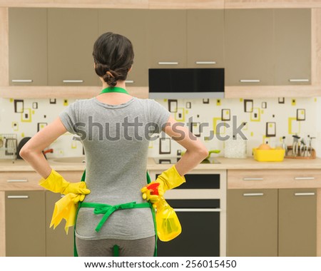 back view of young housewife getting ready for kitchen cleaning