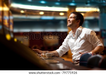 smiling handsome man hoping to win at slot machine