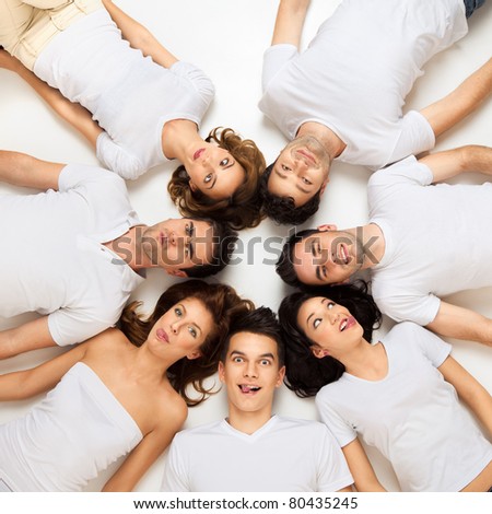 friends posing laying down on the floor looking at camera
