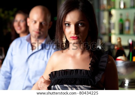 man holding young woman\'s arm, not letting her go