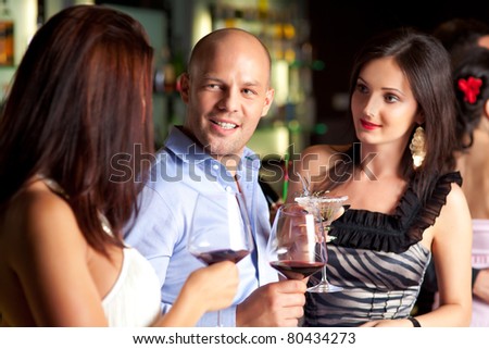 young man talking to beautiful women at the bar