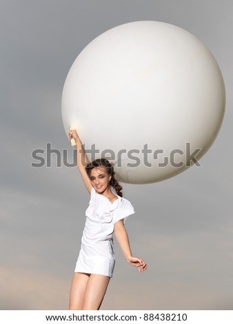 happy, young woman jumping with big, white balloon