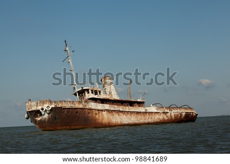 side view of abandoned wrecked ship in seaside landscape