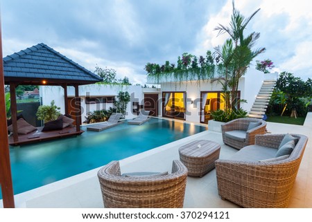 Modern villa outdoor with swimming pool and gazebo at sunset