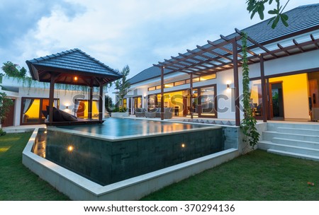 Modern villa outdoor with swimming pool and gazebo at sunset