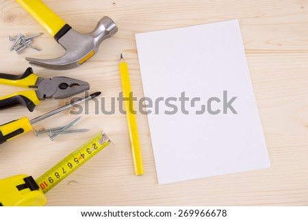 Planning a Project in Carpentry and Woodwork Industry - paper pencil and a set of tools on a wood background.